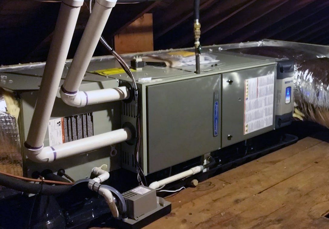 An air conditioner is sitting in the attic of a house.