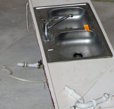 A stainless steel kitchen sink with two sinks and a faucet