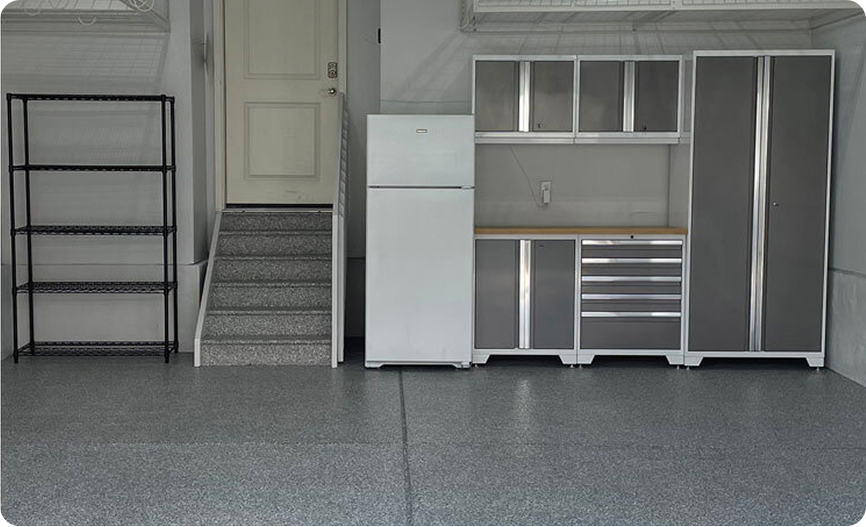A white refrigerator sits in a garage next to a staircase