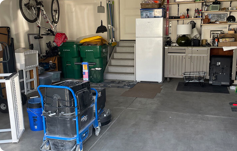 A very cluttered garage with a bicycle on the wall