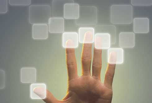 A hand is touching a screen with squares coming out of it.