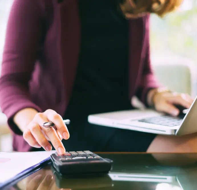 An Accountant Analysing Financial Data with A Calculator and Laptop — SDM Accounting & Taxation Services In Cooroy, QLD