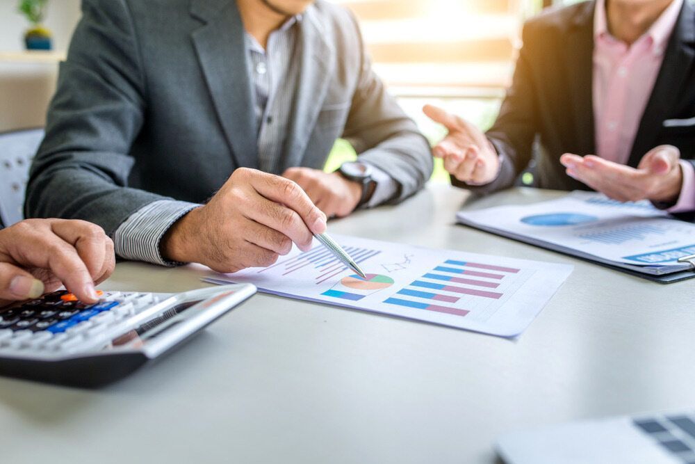 Business People In Suits Reviewing Financial Reports — SDM Accounting & Taxation Services In Cooroy, QLD