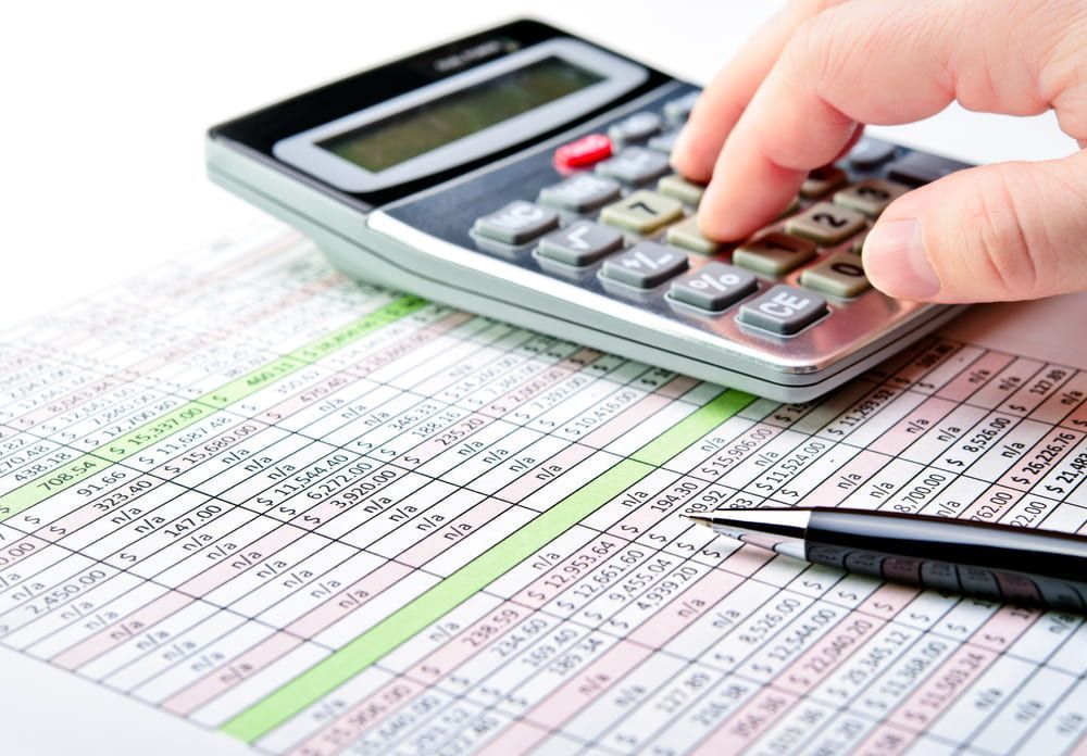 Person Using a Calculator on A Spreadsheet with A Pen Resting on The Paper — SDM Accounting & Taxation Services In Cooroy, QLD