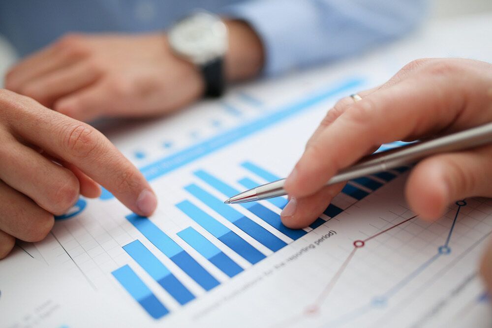 Hands Pointing At A Bar Graph With Blue Bars, Analyzing Financial Data On A Document — SDM Accounting & Taxation Services In Cooroy, QLD