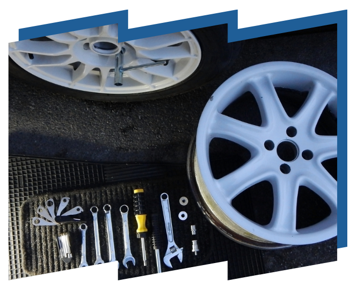 A white wheel is sitting next to a bunch of tools