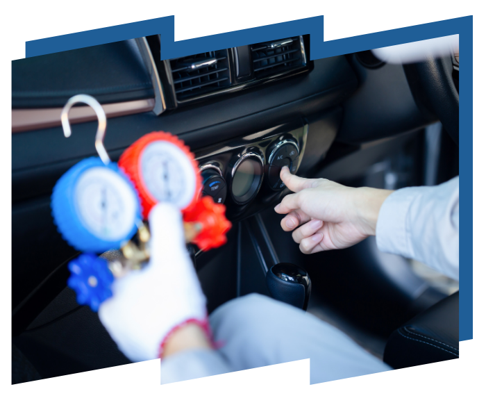 A person is holding two gauges in their hand in a car.