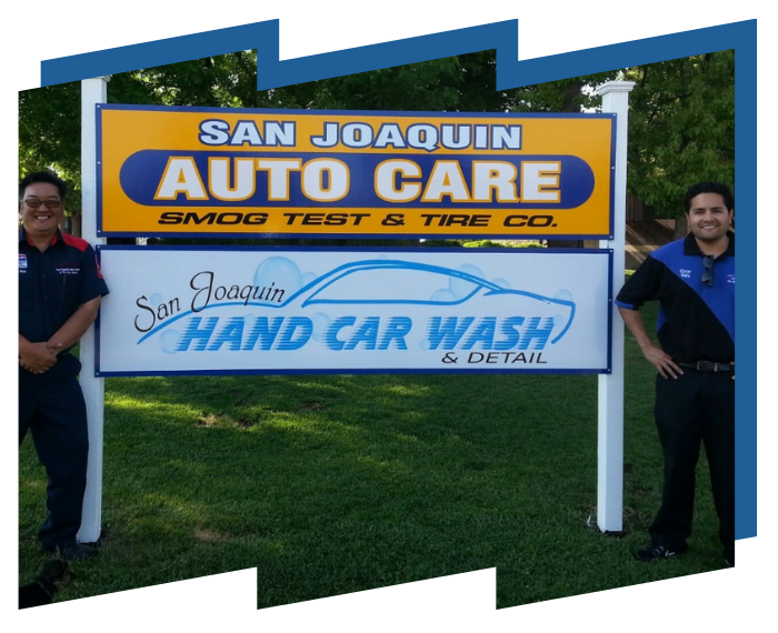 Two men standing under a sign for san joaquin auto care