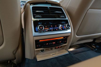 The back seat of a car has a rear air conditioner and a cd player.