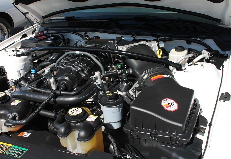 The engine of a white car with the hood open