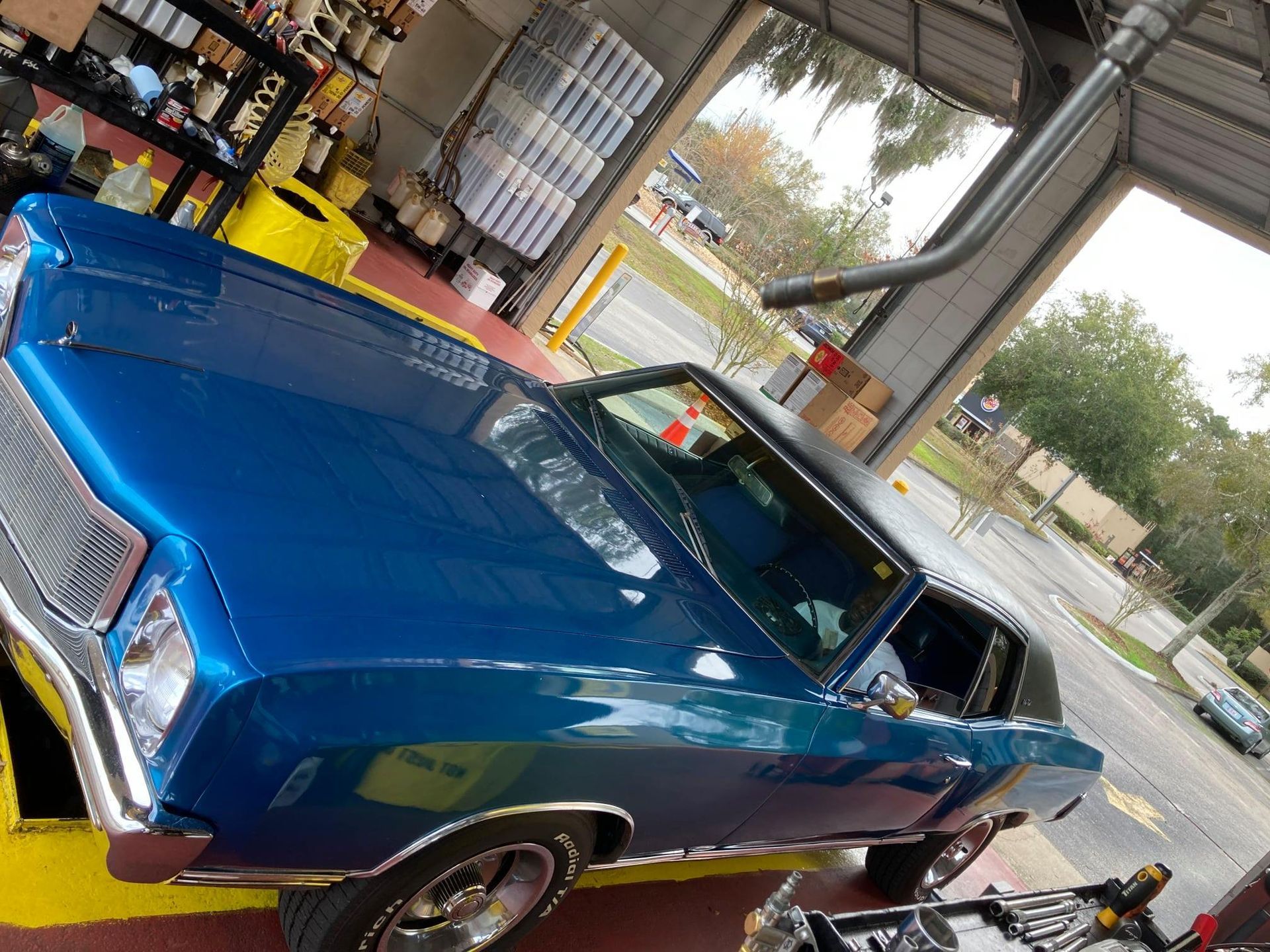 A blue car is parked in a garage.