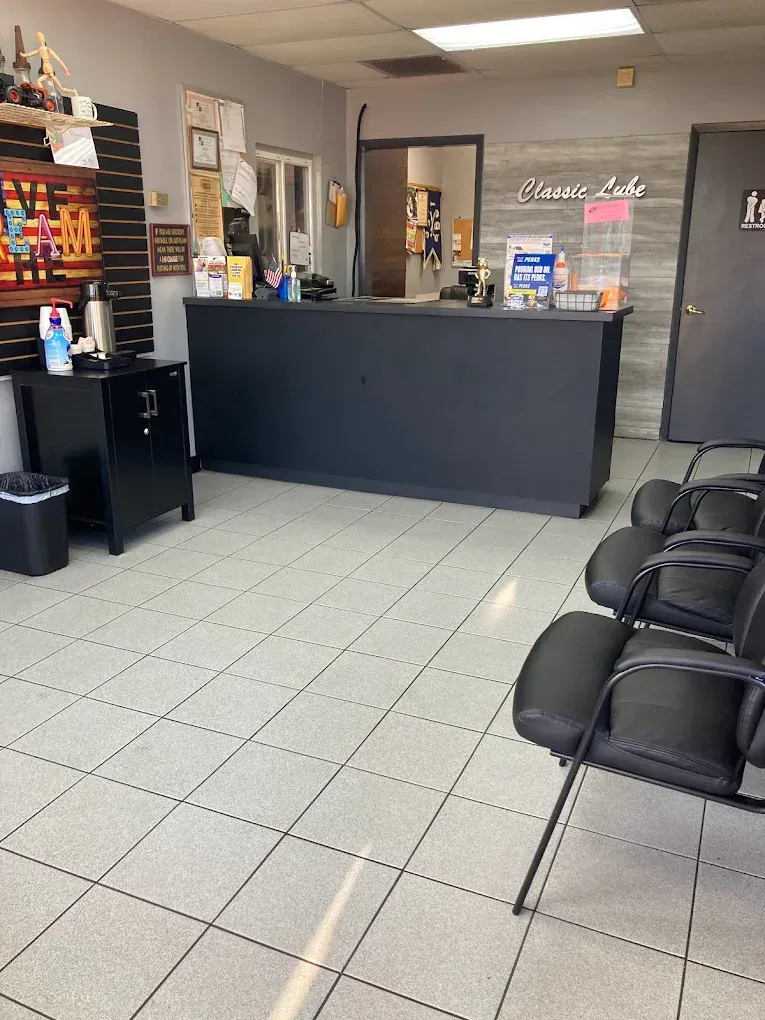 A waiting room with chairs and a counter in a store.