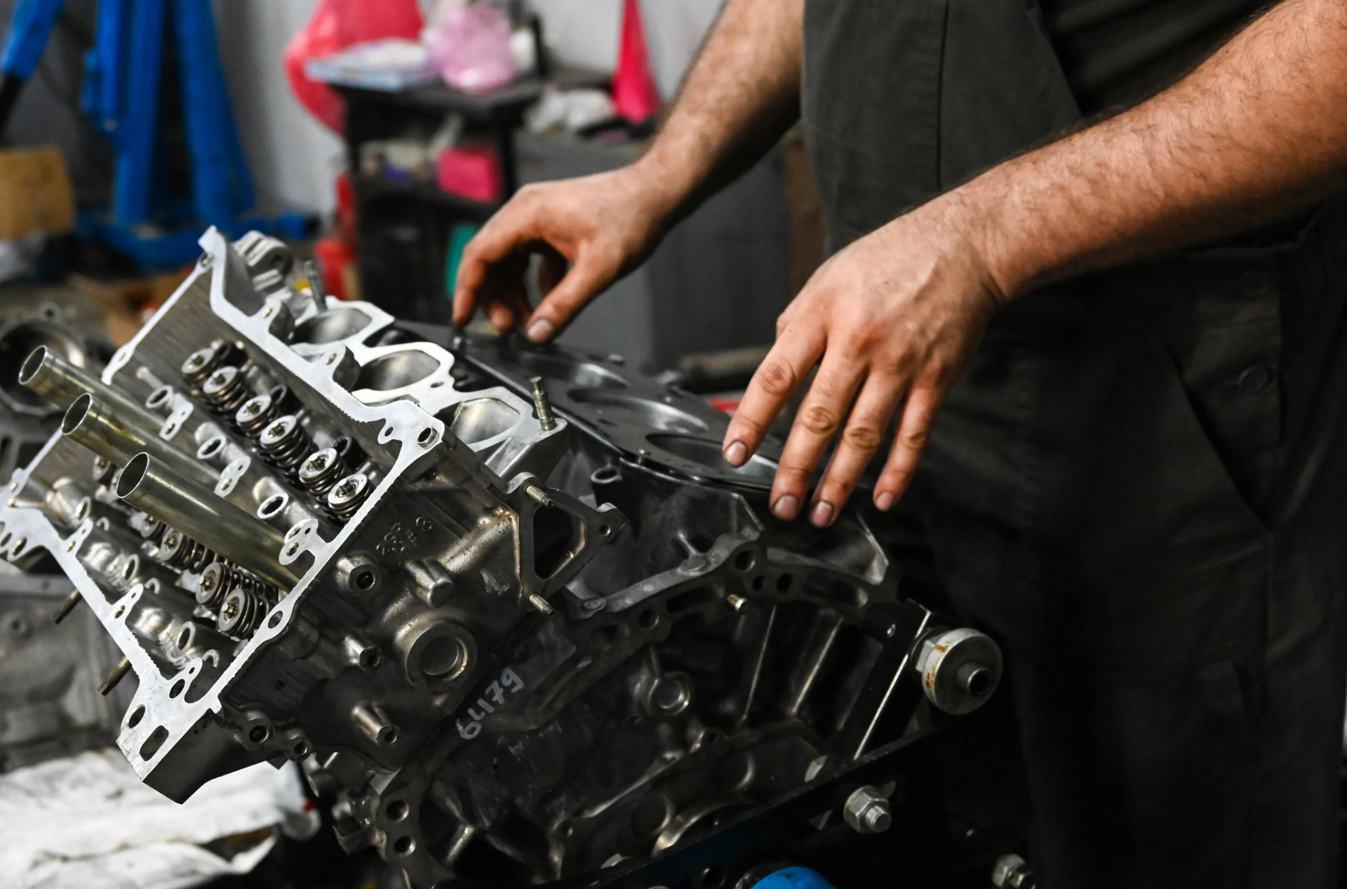 A man is working on a car engine in a garage.