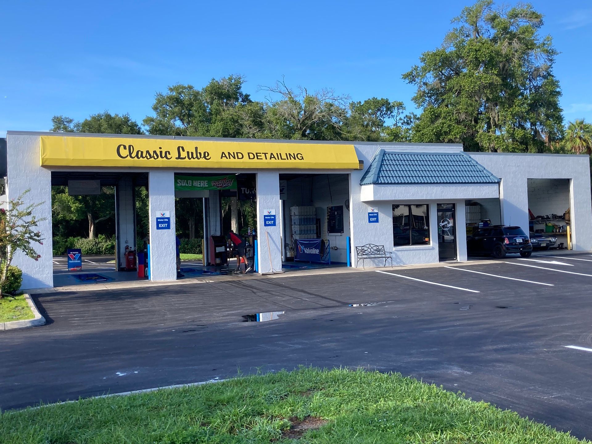 A car wash with a yellow sign that says classic lube and service