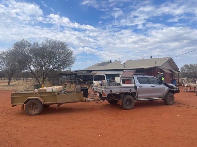 A ute with a trailer parked on red dirt in front of a house — Alice Springs Electrical Services In Araluen, NT