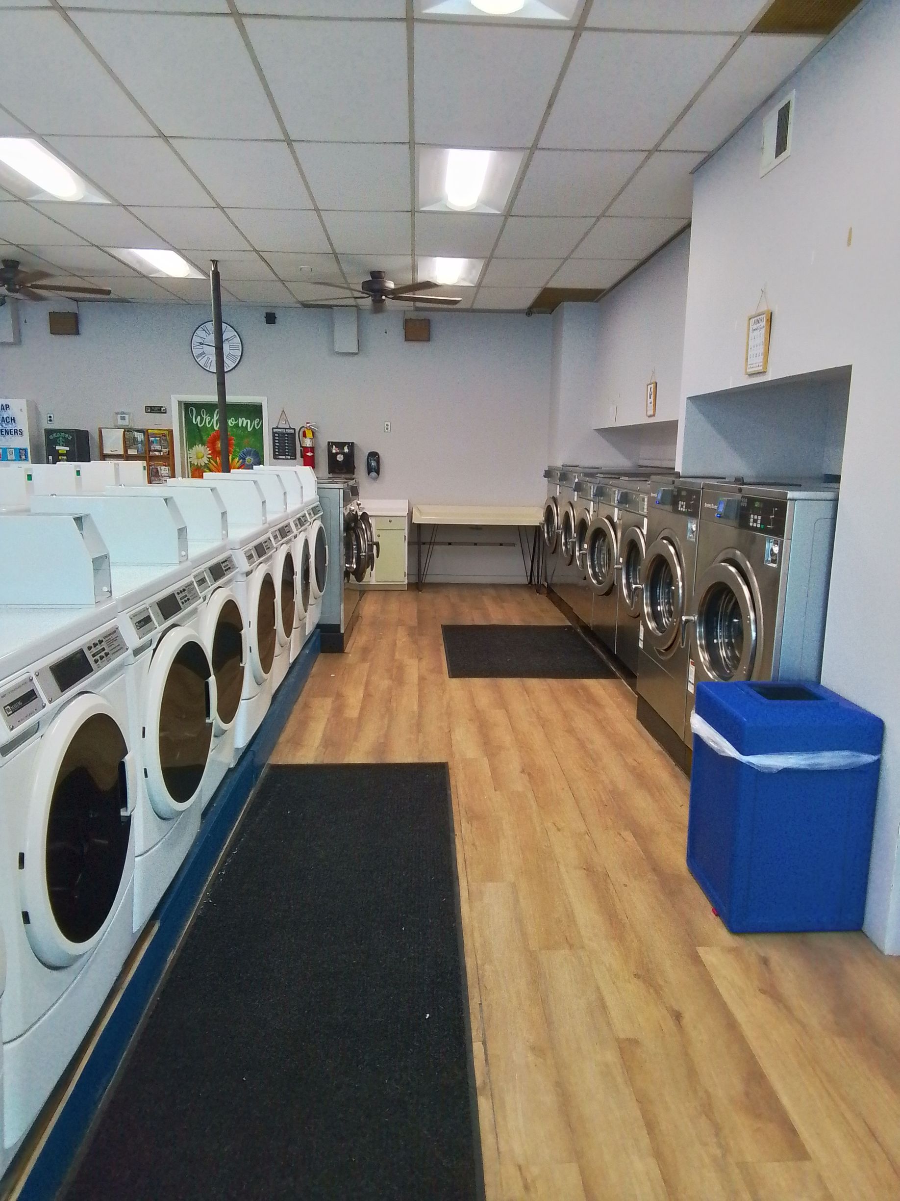 A woman is putting clothes in a washing machine.
