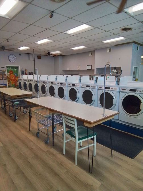 A row of washing machines are lined up in a laundromat.