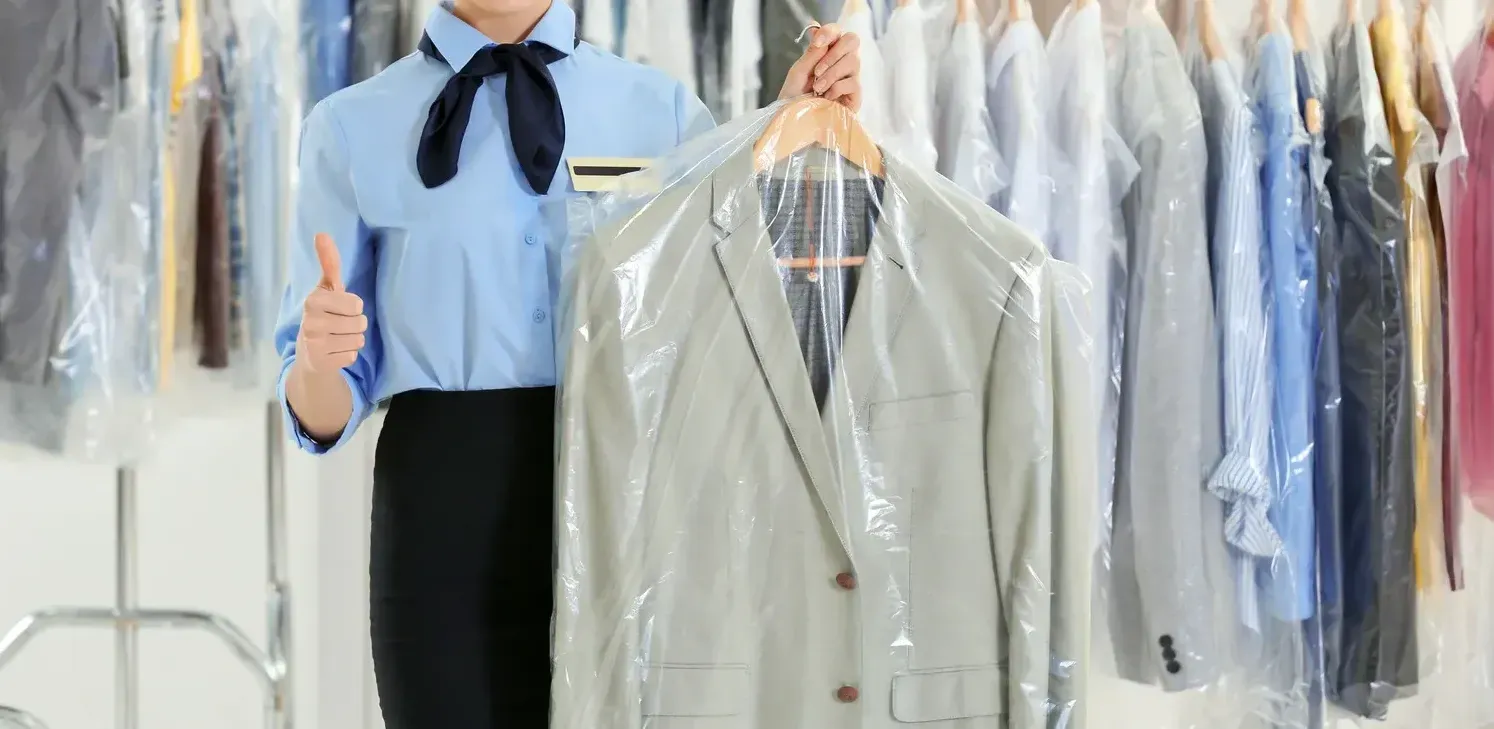A row of blue shirts are hanging on a rack