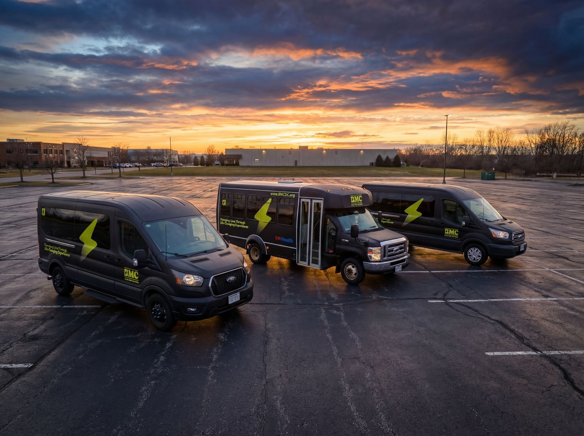 Blue van driving on a wet road, with blurred green and yellow background.