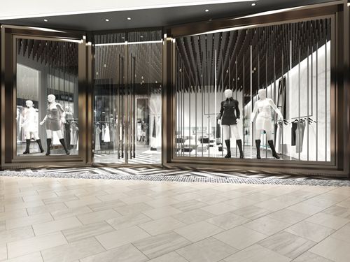Glass storefront with bronze trim, showcasing mannequins dressed in black and white attire.