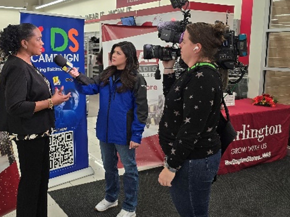Woman being interviewed at Burlington store; crew filming.