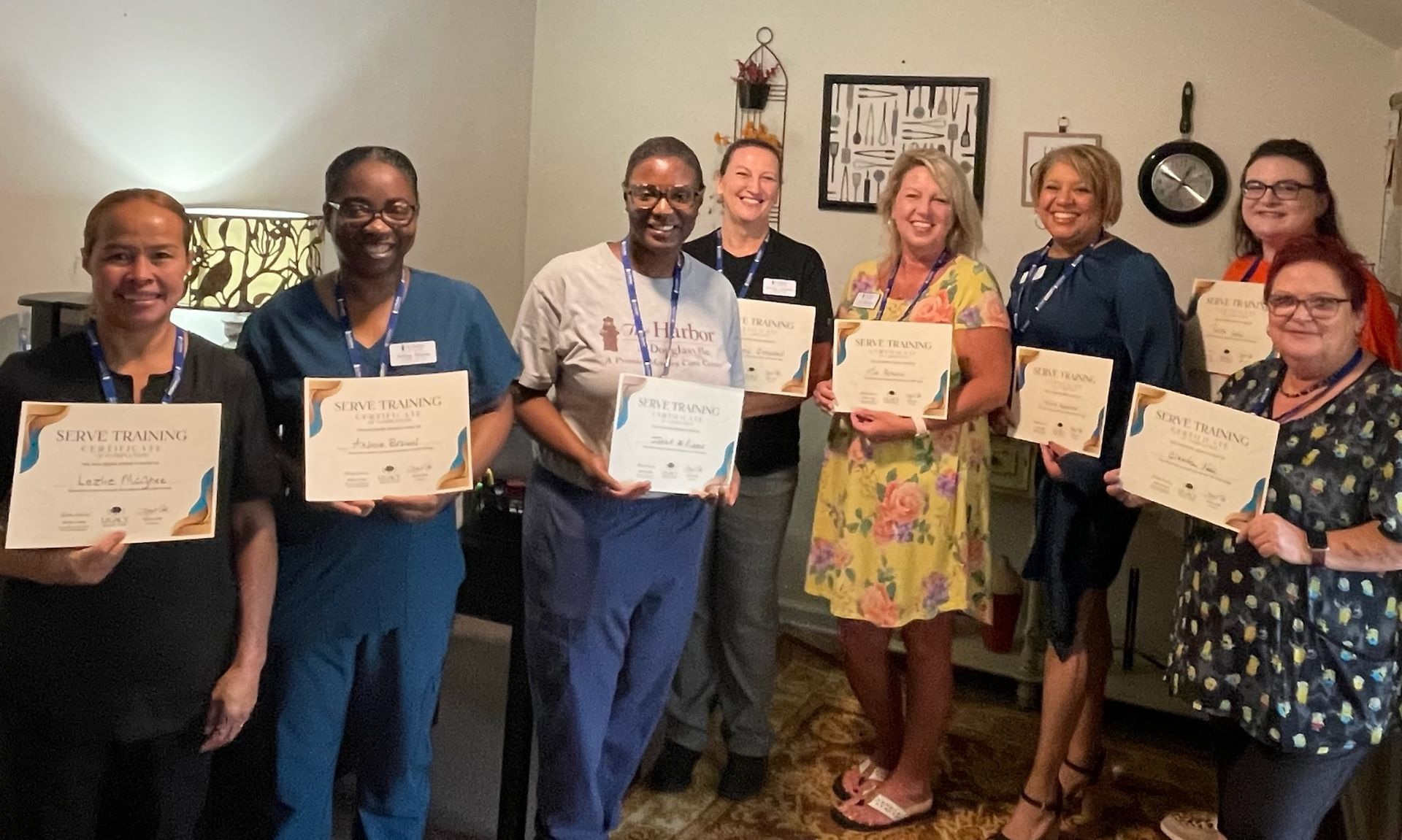 A group of people are standing in a room holding certificates.