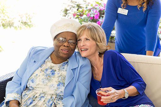 Two women are sitting next to each other on a couch.