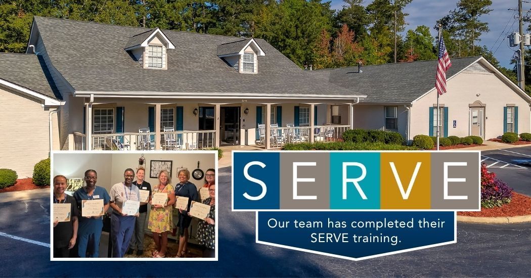 A group of people standing in front of a house with a sign that says serve