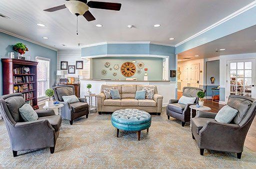 A living room filled with furniture and a ceiling fan.