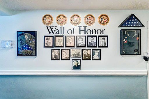 A wall of honor with pictures of soldiers on it.