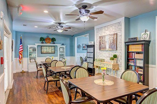 A large dining room with tables and chairs and a ceiling fan.