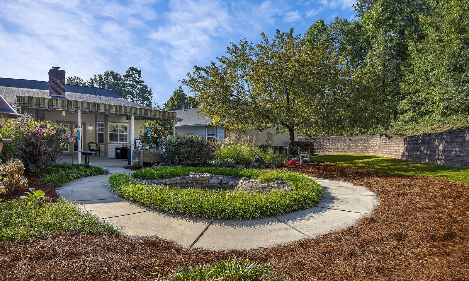There is a circular walkway in the middle of the yard.