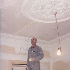 man standing under large ornate ceiling