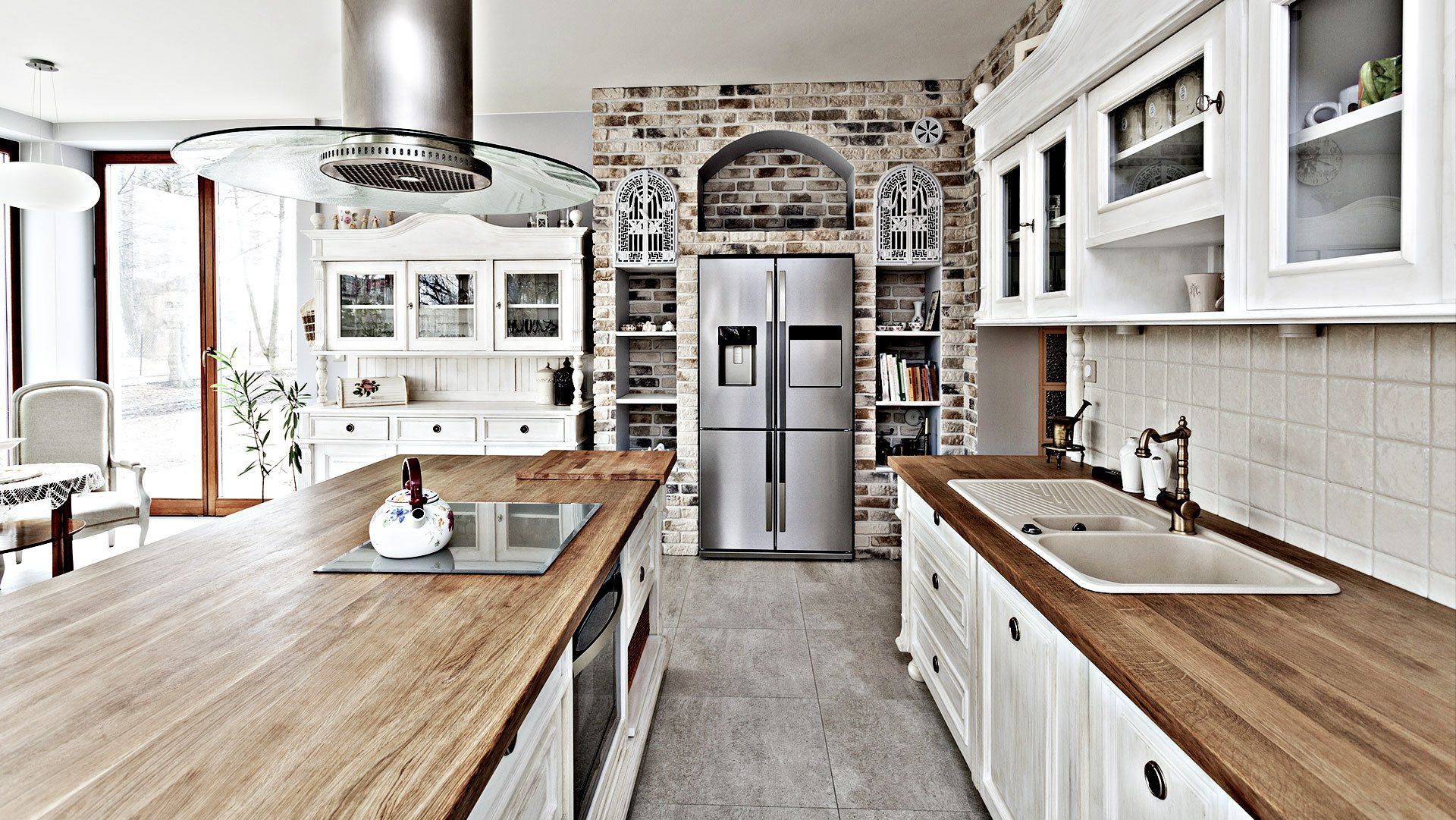 A kitchen with stainless steel appliances and wooden counter tops.