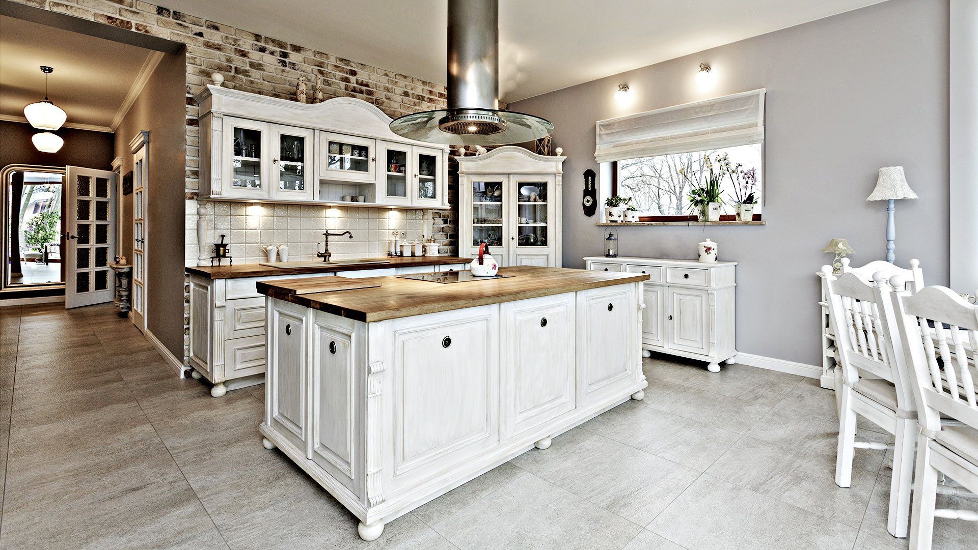A kitchen with white cabinets and a large island in the middle