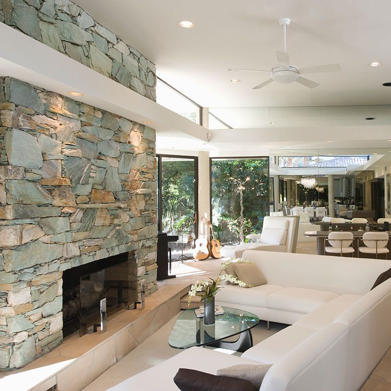 A living room with a stone wall and a fireplace