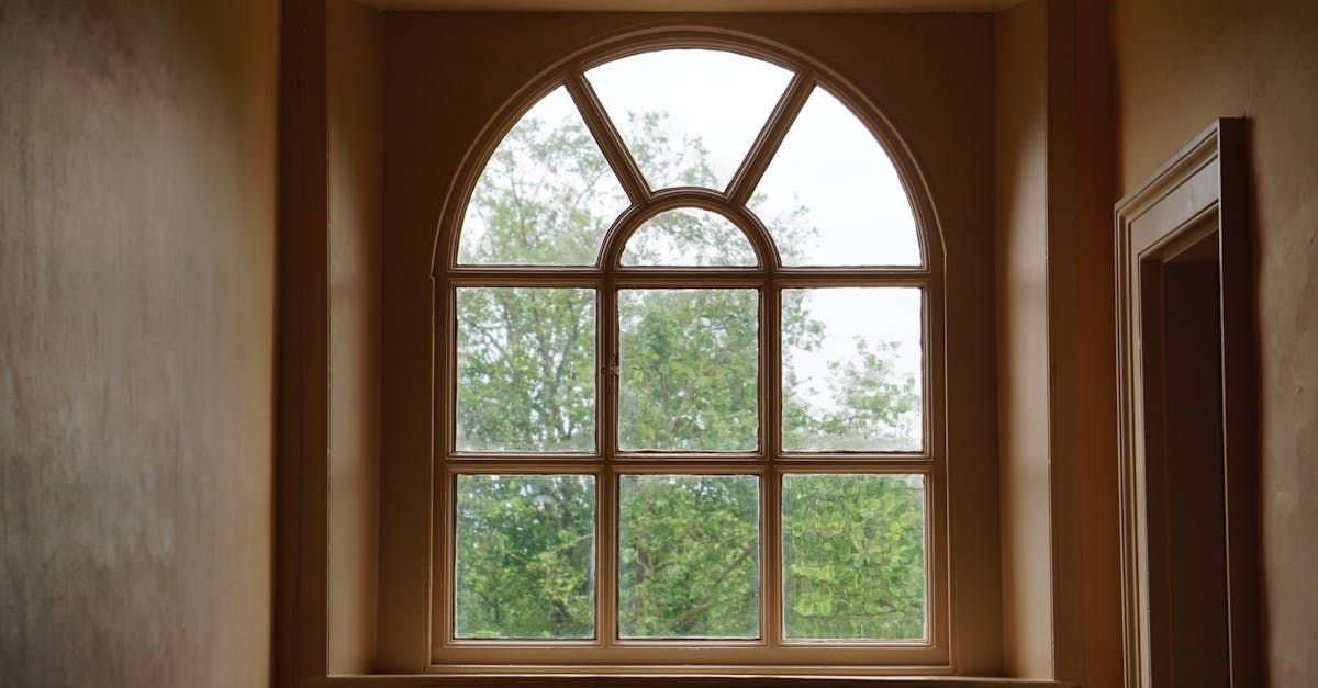 A man is measuring a window with a tape measure.