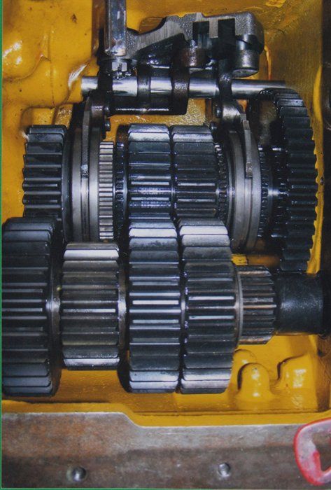Yellow transmission housing with gears and shafts.