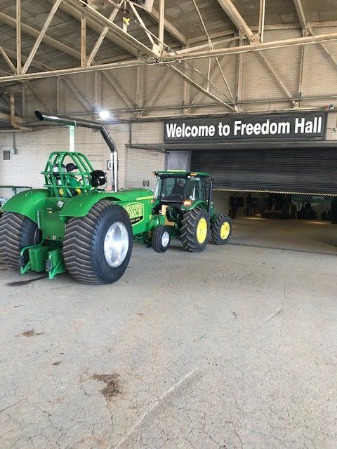 Two green tractors near entrance of Freedom Hall.