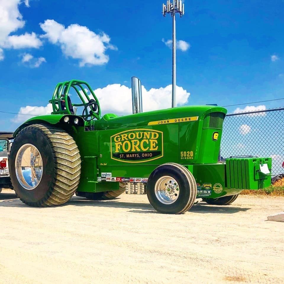 Green tractor pulling vehicle, 
