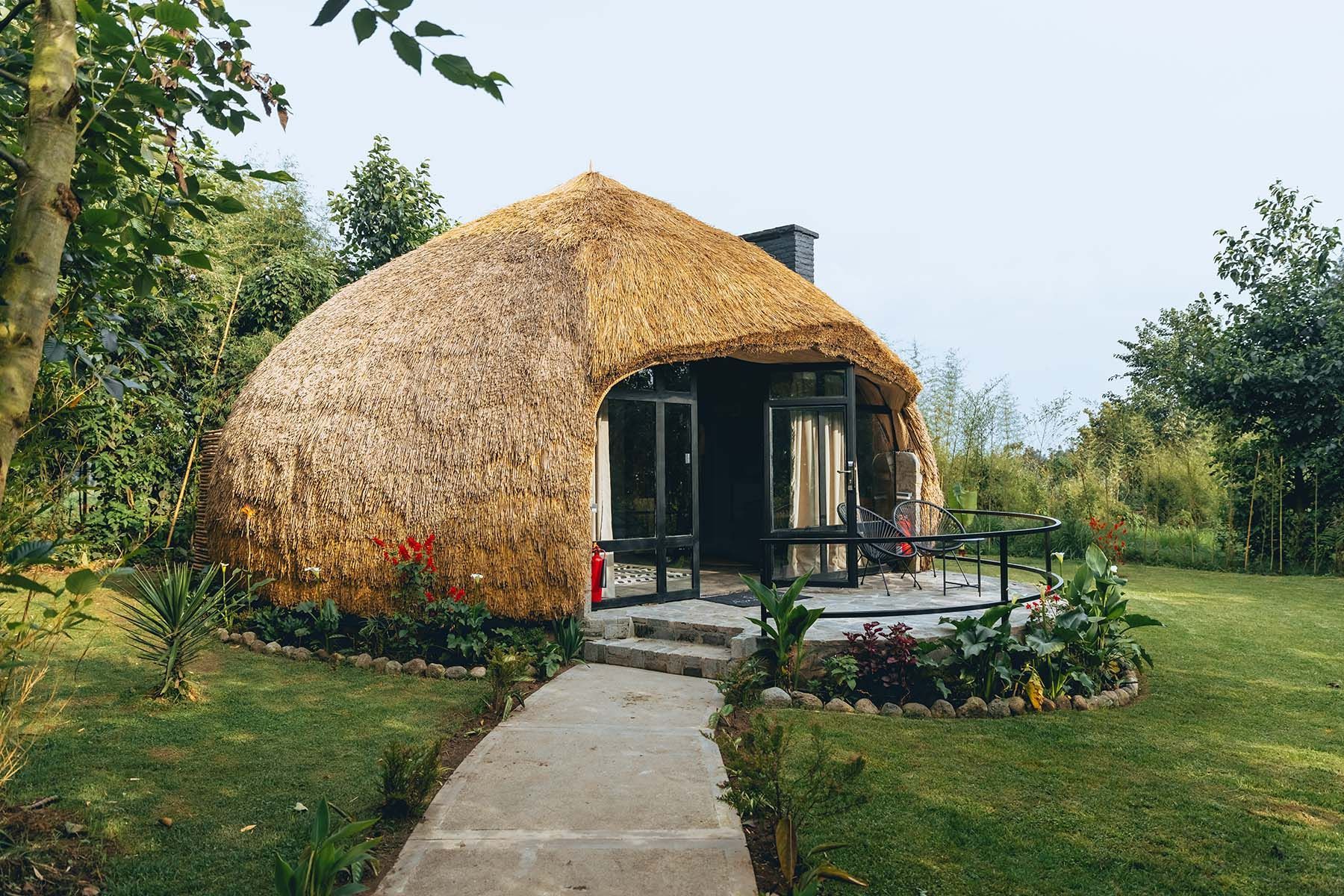 A bedroom with a canopy bed , chair , rug and sliding glass doors.