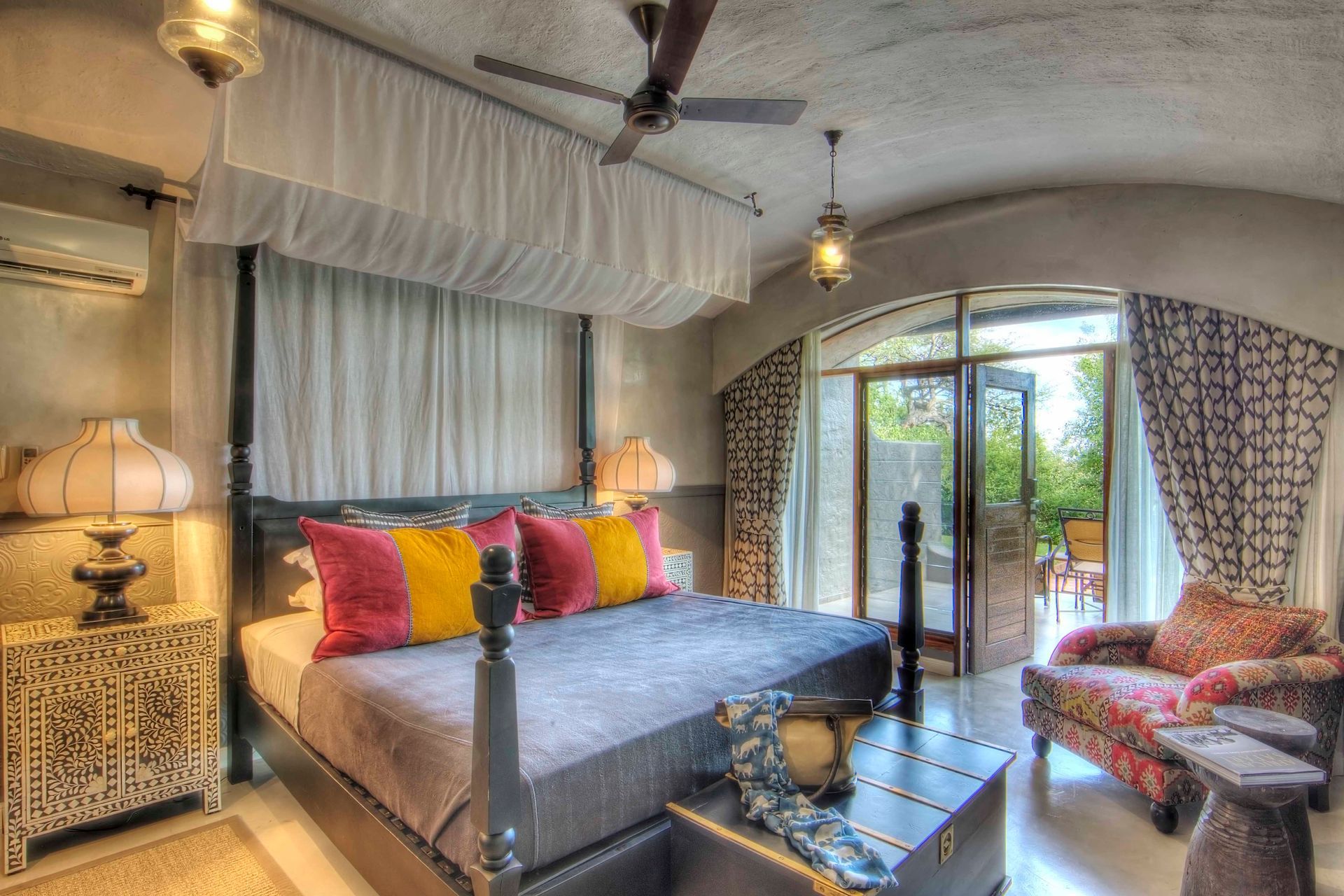 A bedroom with a canopy bed and a ceiling fan