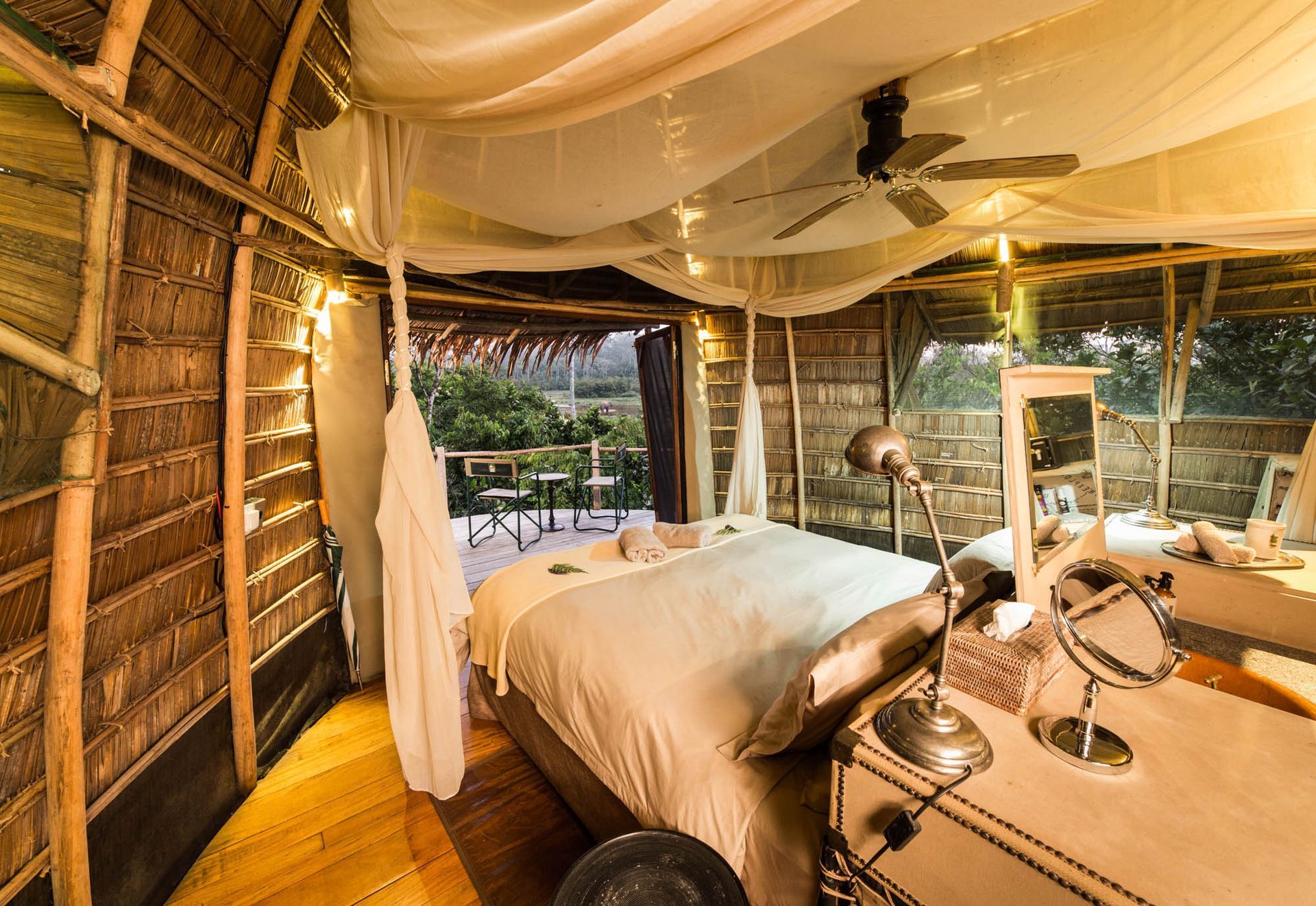 A bedroom with a canopy bed and a ceiling fan.
