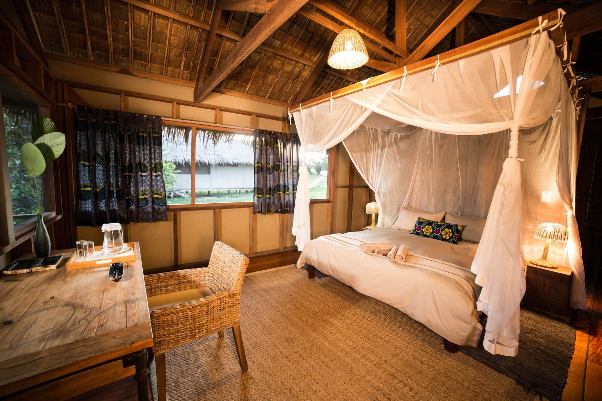 A bedroom with a canopy bed and a desk.