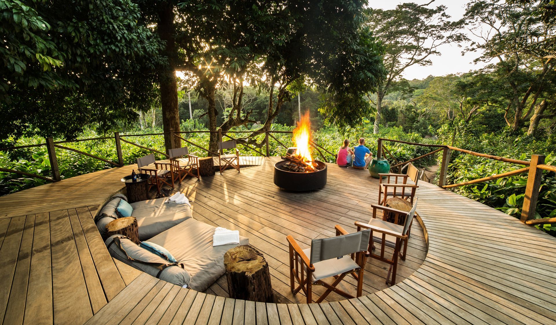 A wooden deck with a fire pit in the middle of it