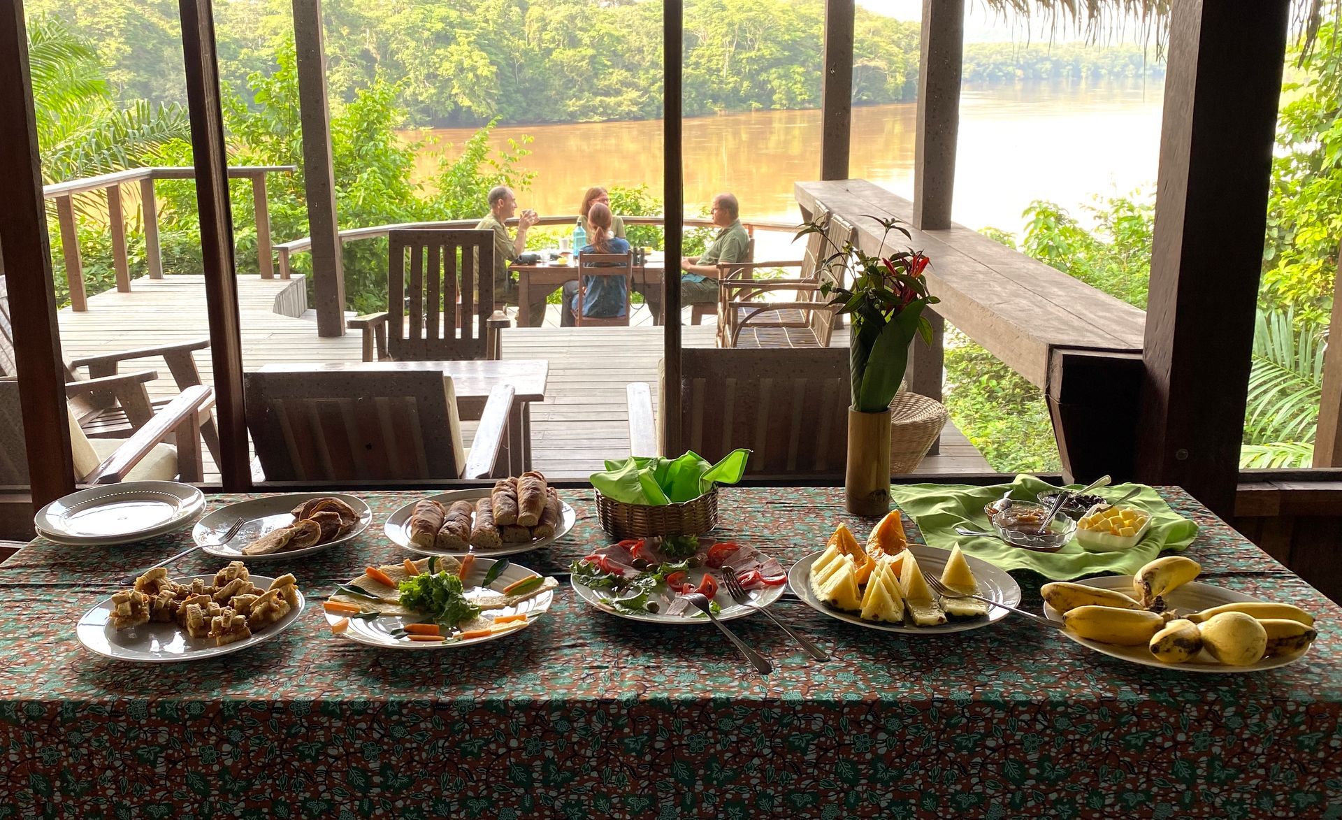 A table with plates of food and a vase of flowers on it
