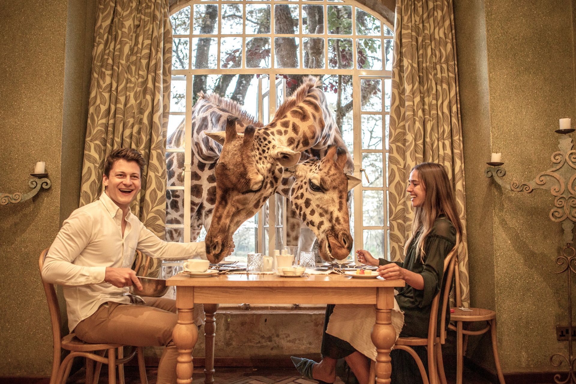 A man and a woman are sitting at a table with a giraffe on it.