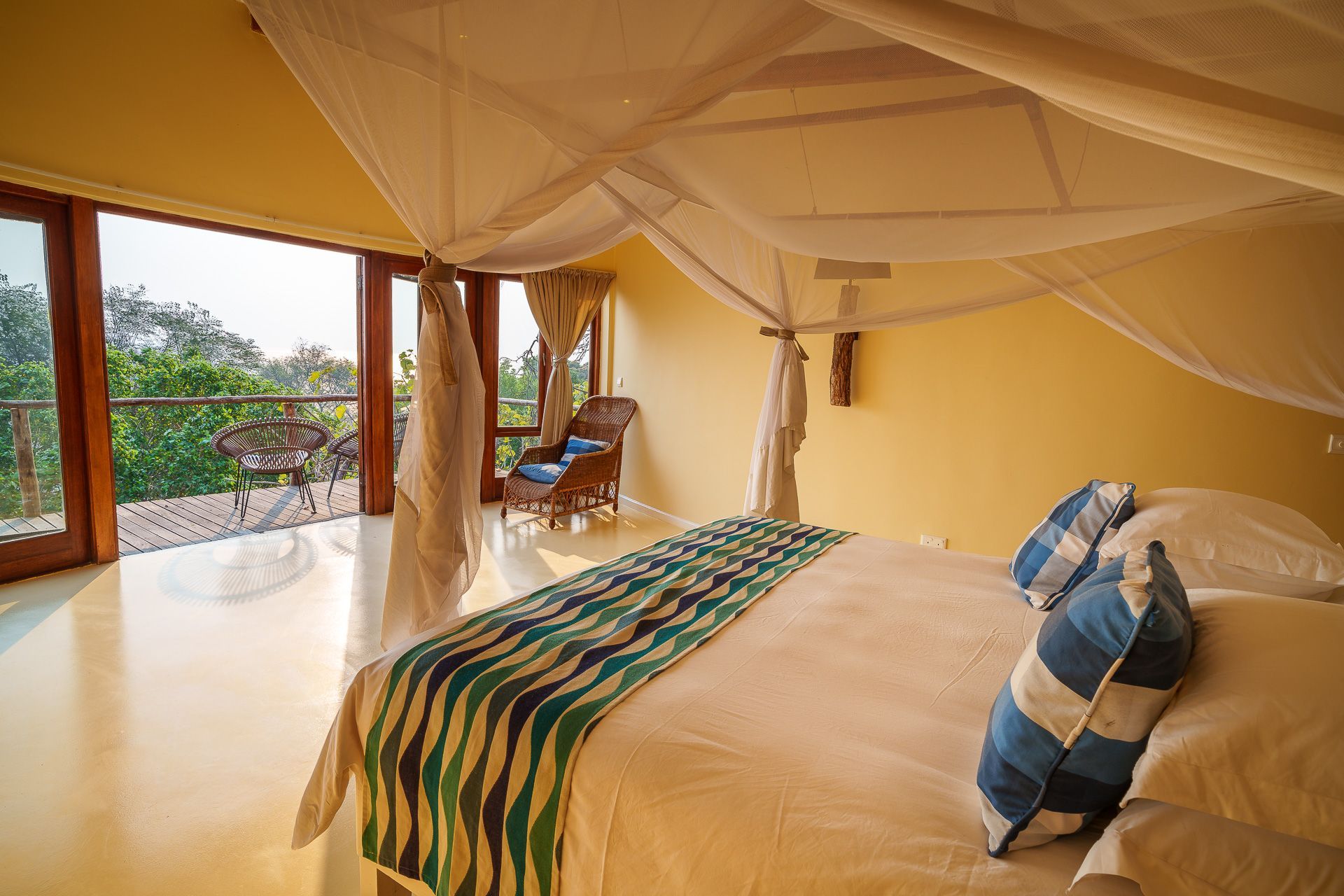 A bedroom with a canopy bed and a balcony.