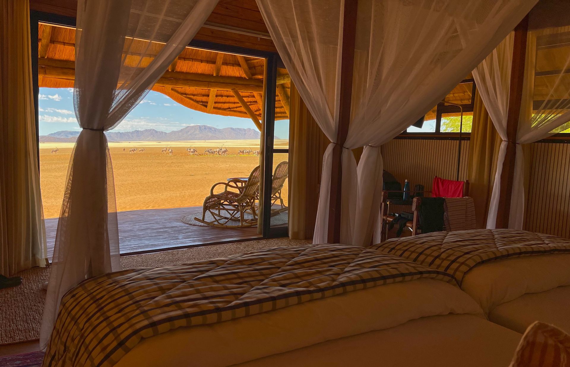A bedroom with a canopy bed and a view of the desert.