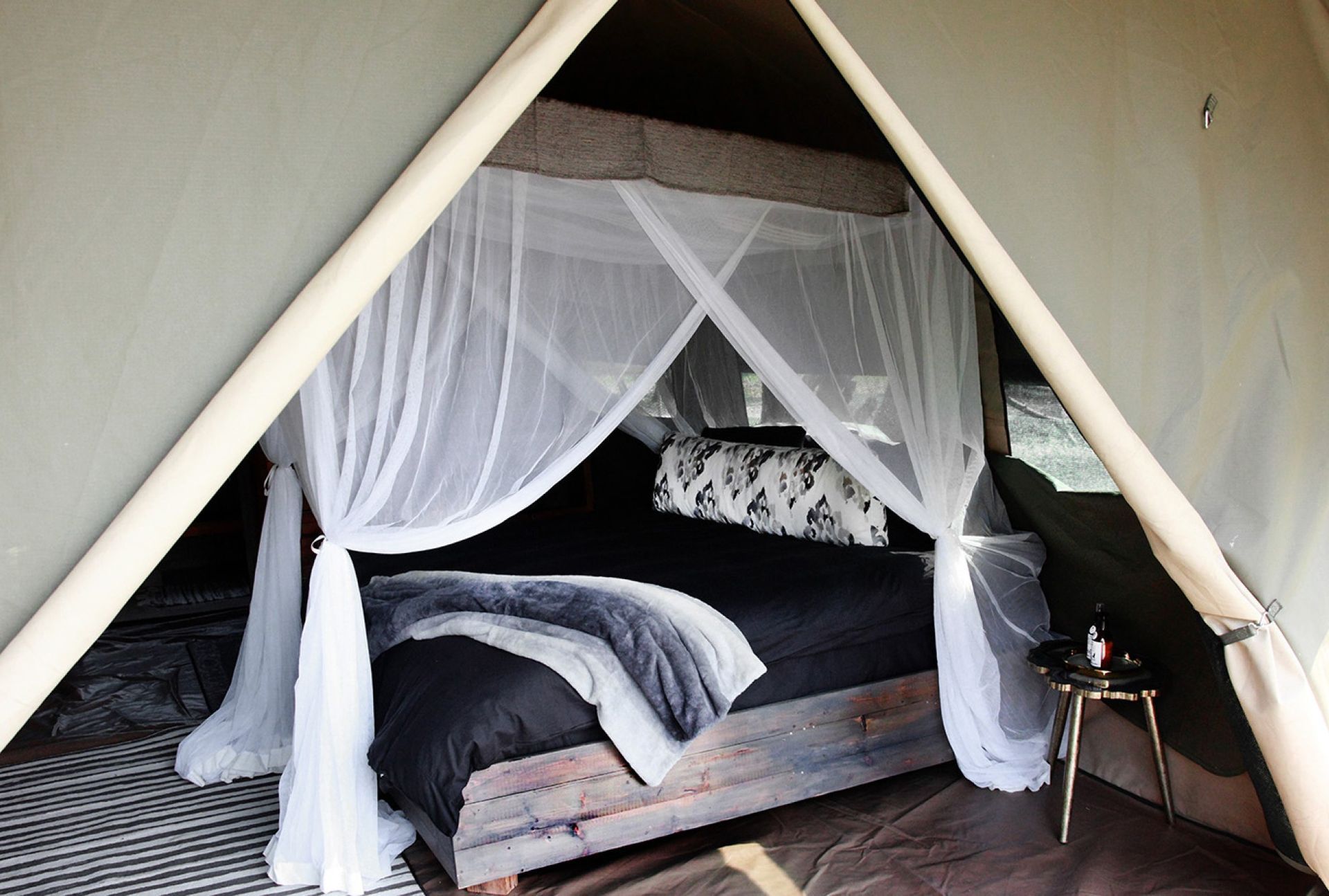 A tent with a canopy bed inside of it